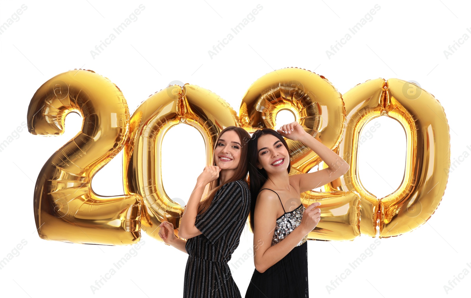 Photo of Happy young women near golden 2020 balloons on white background. New Year celebration