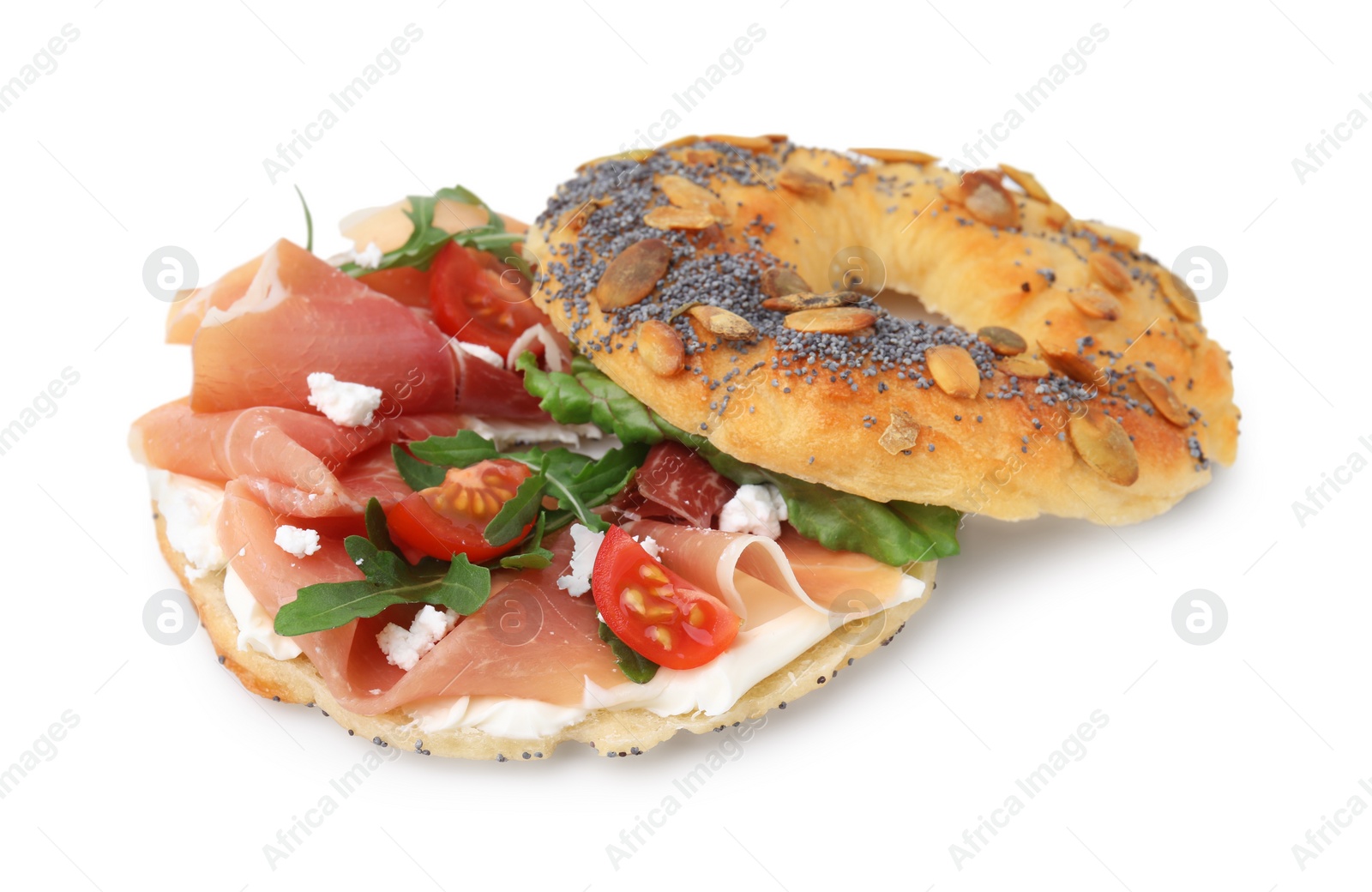 Photo of Tasty bagel with cured ham, arugula, cream cheese and tomatoes isolated on white