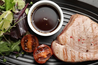 Delicious tuna steak, salad, tomato and sauce in serving dish, top view