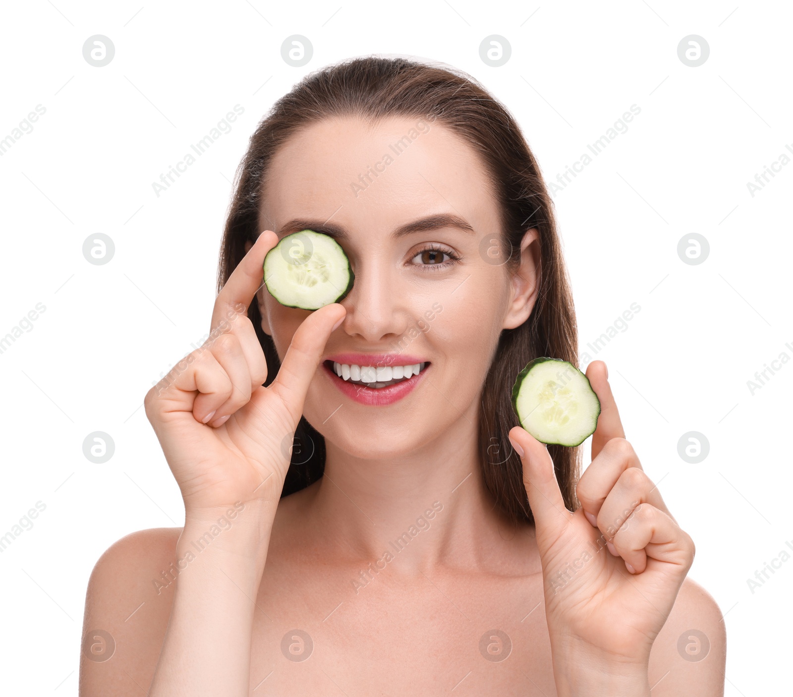 Photo of Beautiful woman covering eye with piece of cucumber on white background