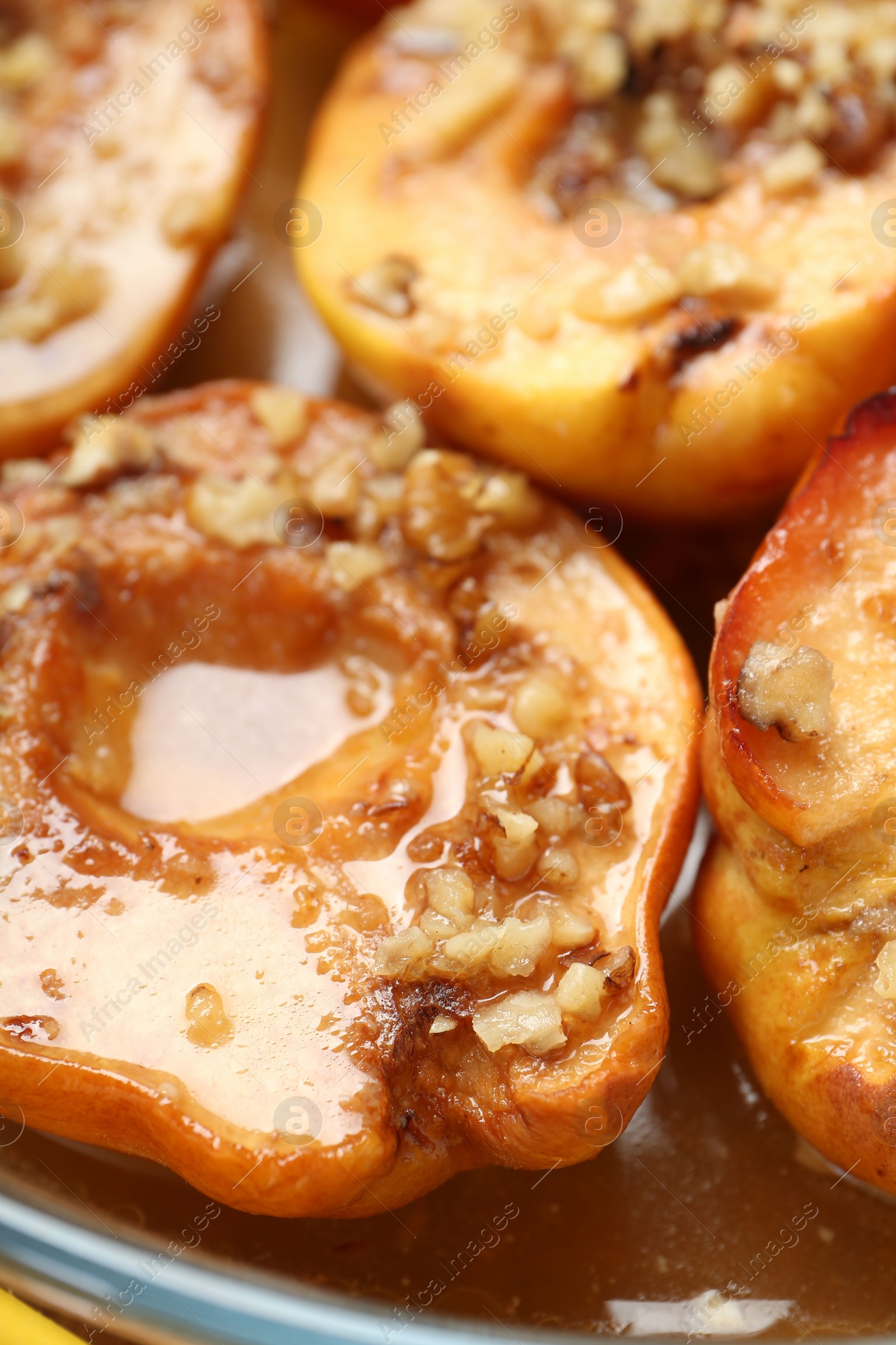 Photo of Tasty baked quinces with walnuts and honey in bowl, closeup