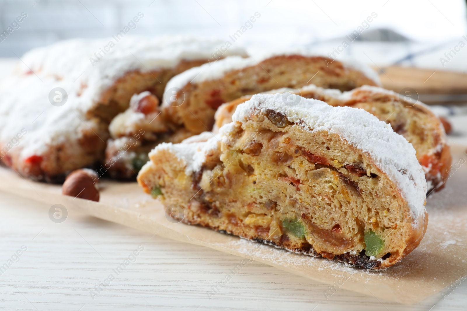 Photo of Traditional Christmas Stollen with icing sugar on white wooden table