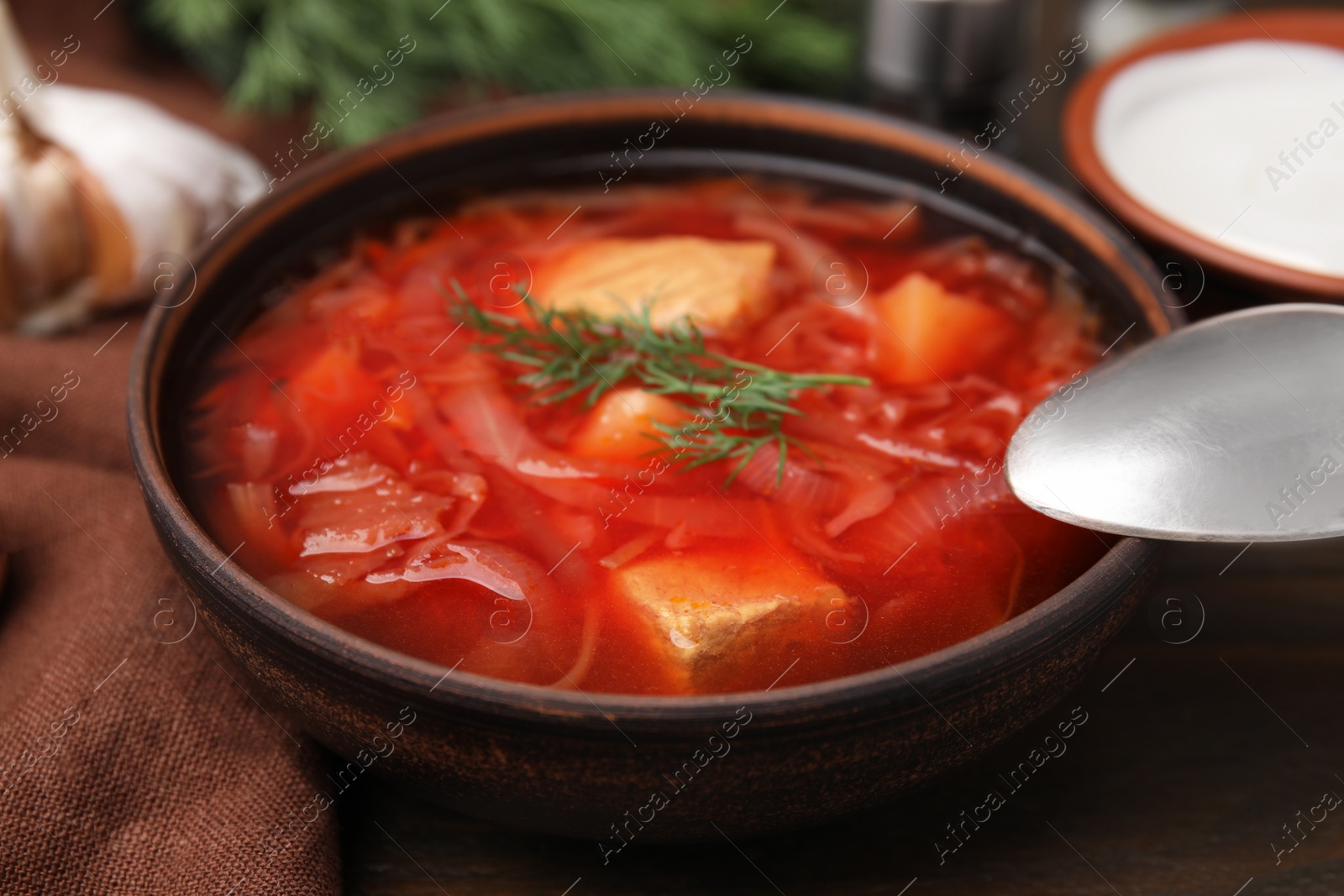 Photo of Bowl of delicious borscht on table, closeup