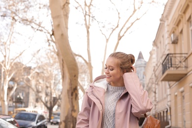 Portrait of happy young woman on city street