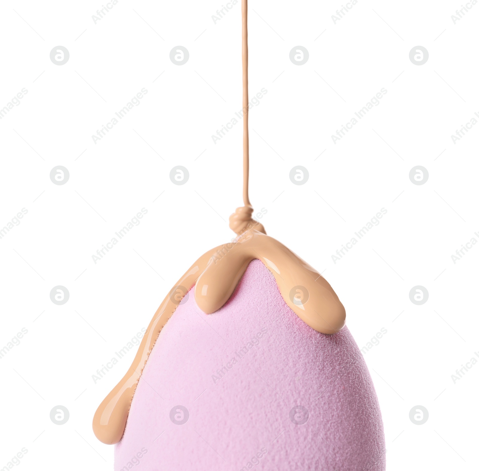 Photo of Pouring skin foundation onto makeup sponge on white background