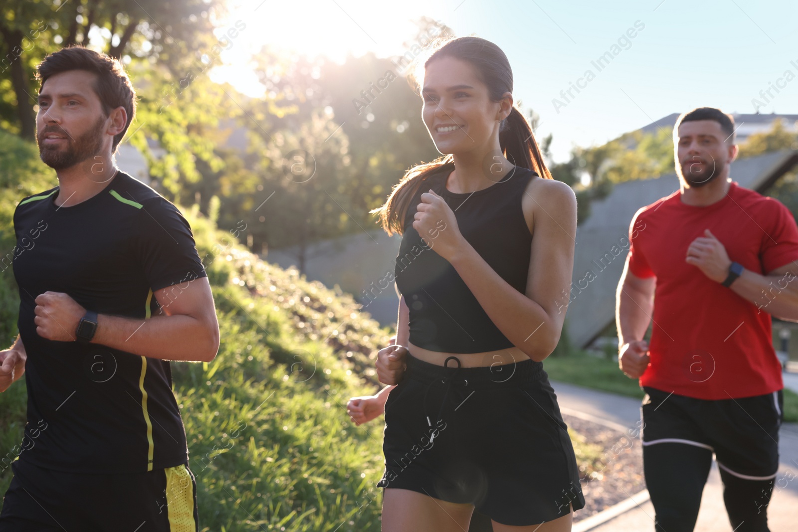 Photo of Group of people running outdoors on sunny day