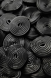 Photo of Tasty black liquorice candies as background, closeup