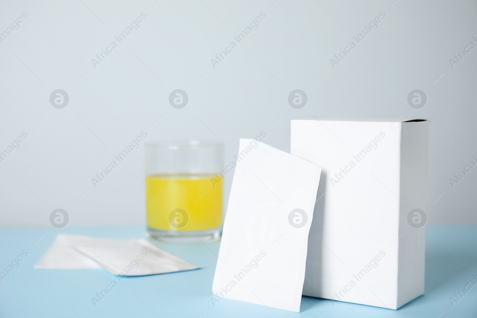 Photo of Medicine sachet and box on turquoise table. Space for text