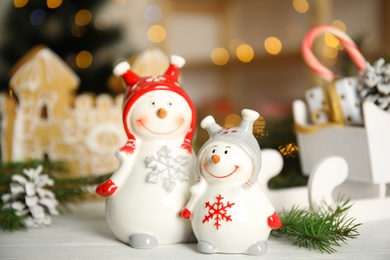Photo of Christmas composition with decorative snowmen on white wooden table