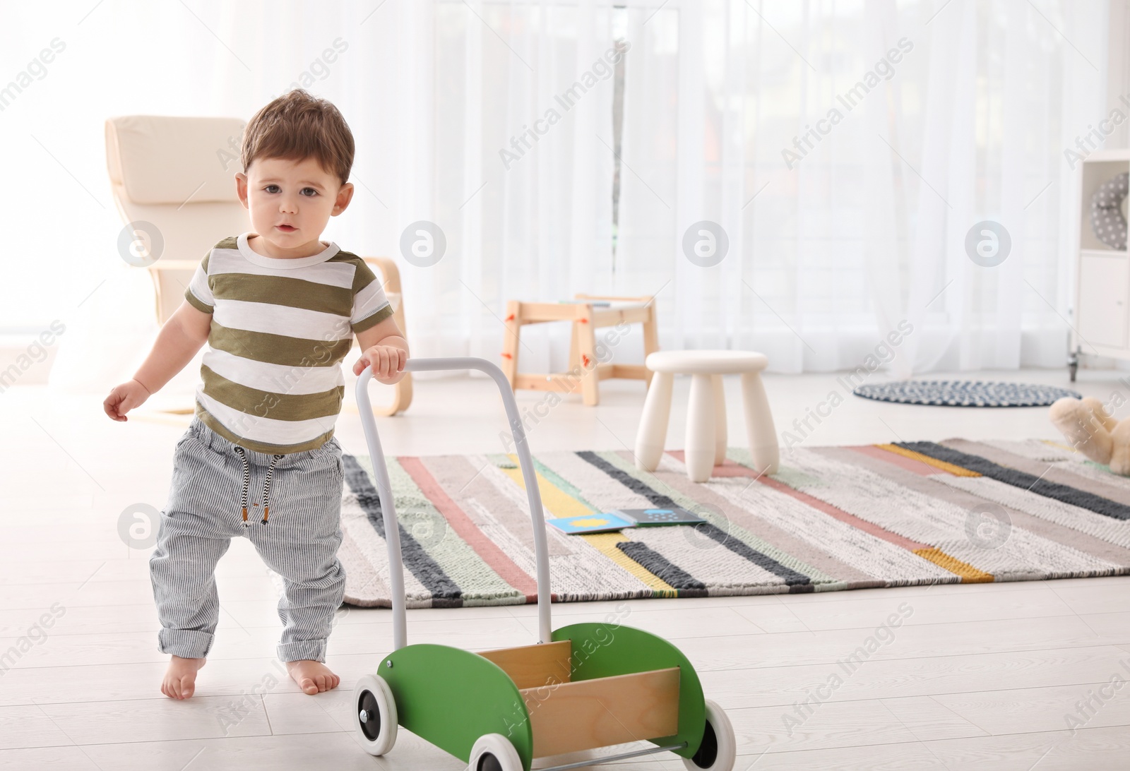 Photo of Cute baby learning to walk and playing at home