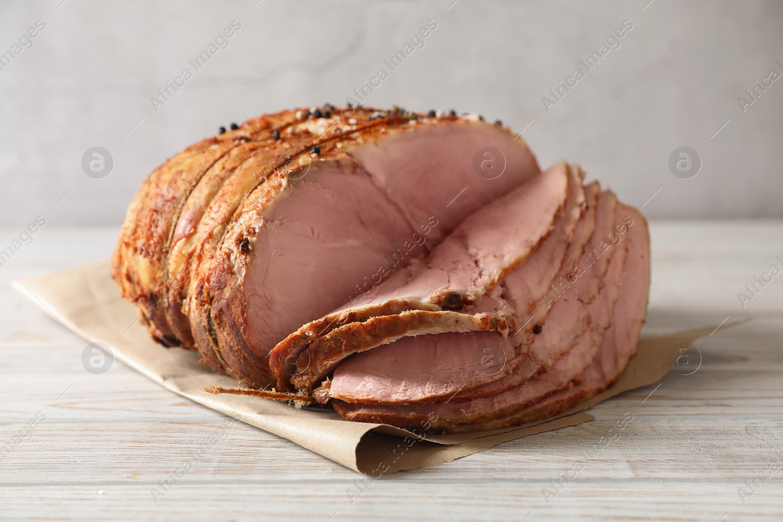 Photo of Delicious sliced baked ham on white wooden table
