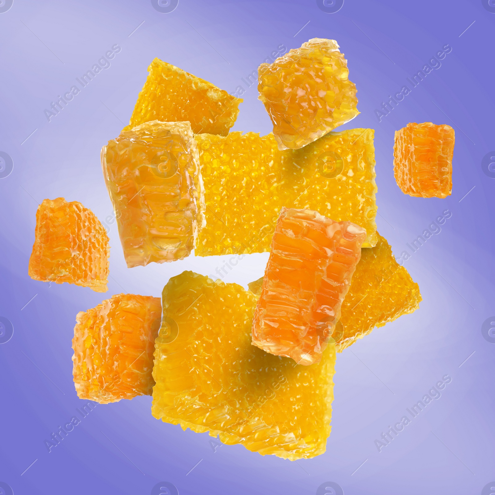 Image of Pieces of honeycomb falling on slate blue background