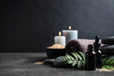 Photo of Spa composition with aroma oil on grey table, space for text