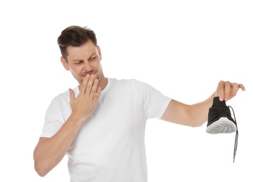 Photo of Man feeling bad smell from shoe on white background. Air freshener