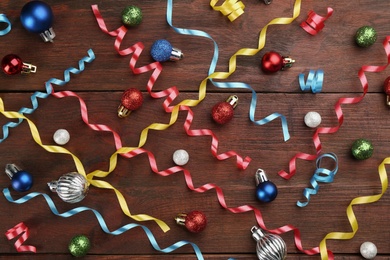 Photo of Flat lay composition with serpentine streamers and Christmas ornaments on wooden background