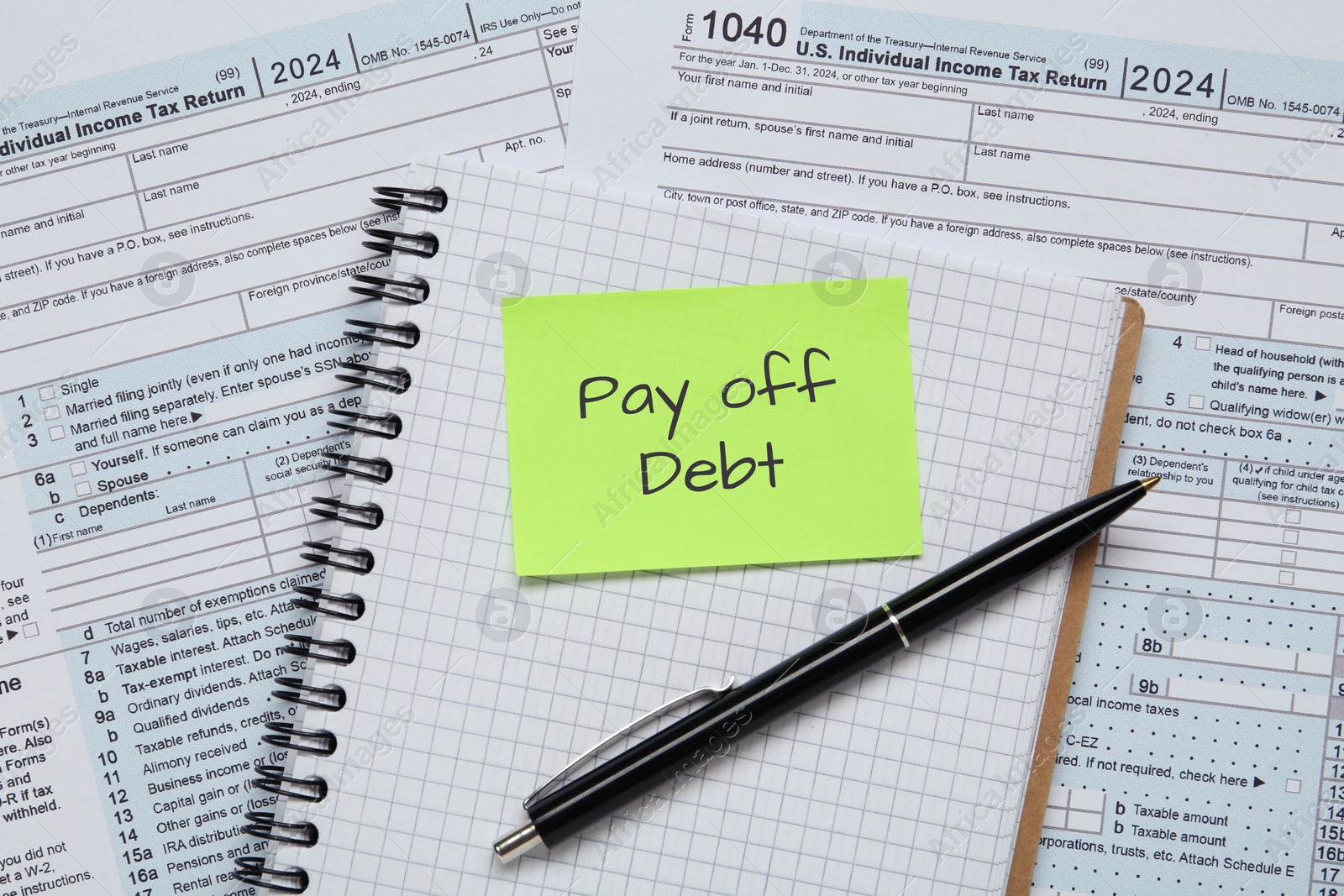 Image of Reminder note with phrase Pay Off Debt, notebook and pen on documents, flat lay