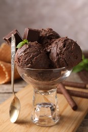 Tasty chocolate ice cream with mint in glass dessert bowl served on table