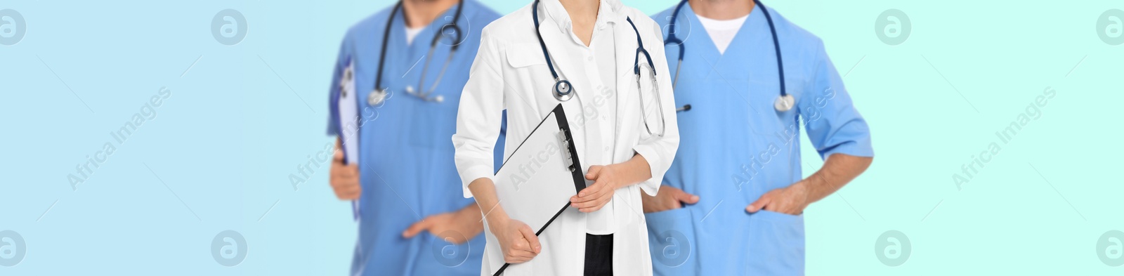 Image of Doctors and nurse on light blue background, closeup. Banner design