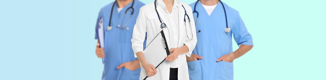 Image of Doctors and nurse on light blue background, closeup. Banner design