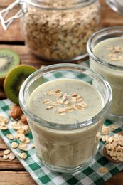 Photo of Tasty kiwi smoothie with oatmeal on wooden table