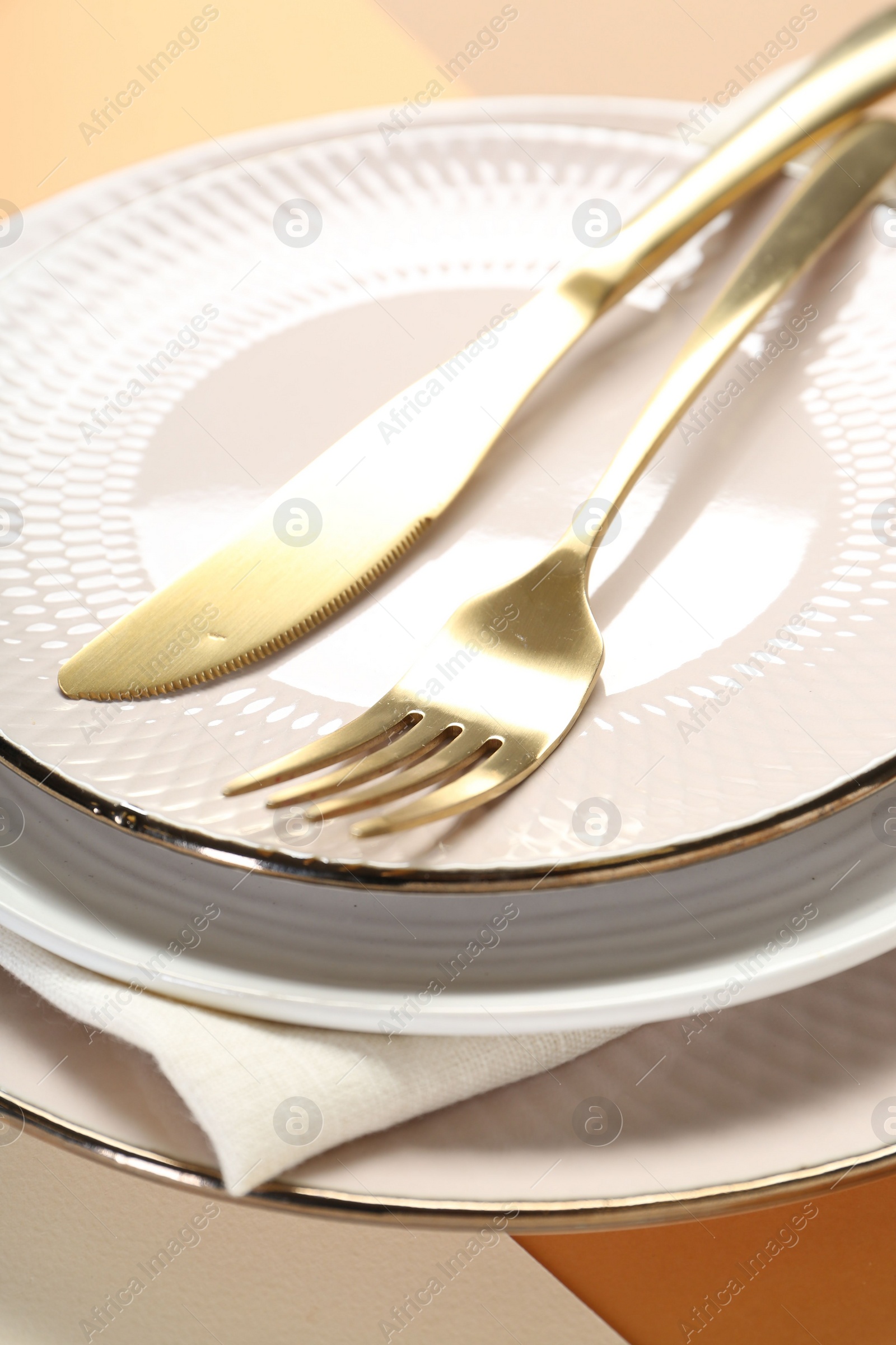 Photo of Ceramic plates, cutlery and napkin on table, closeup