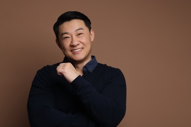 Photo of Portrait of happy man on brown background. Space for text