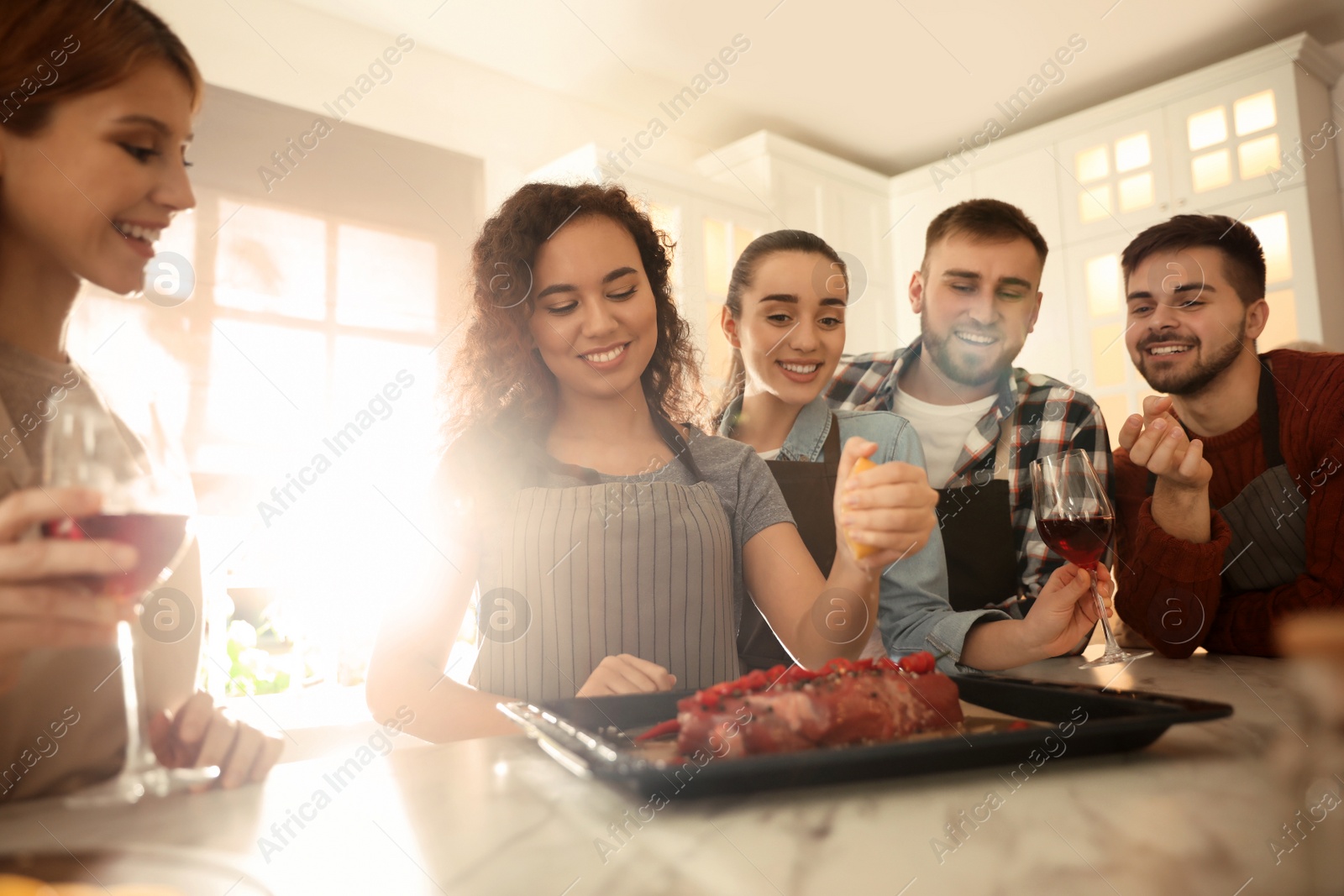 Photo of Happy people cooking food together in kitchen