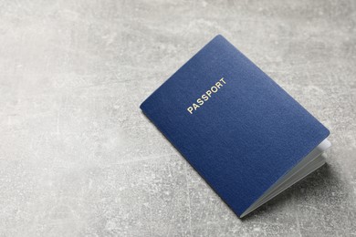 Blank blue passport on grey table , space for text