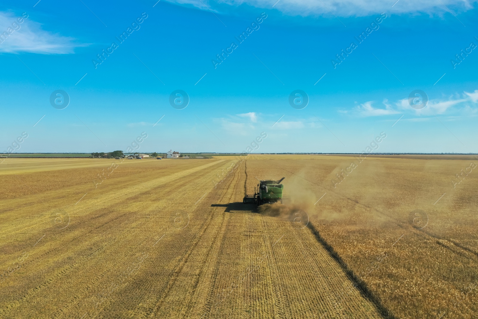 Photo of Modern combine harvester working in field on sunny day. Agriculture industry