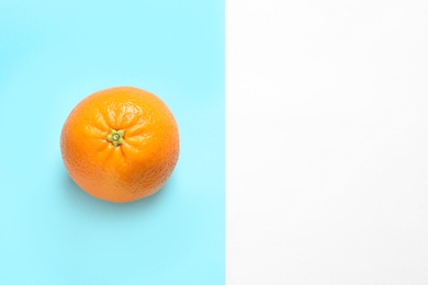 Photo of Ripe orange and space for text on color background, top view