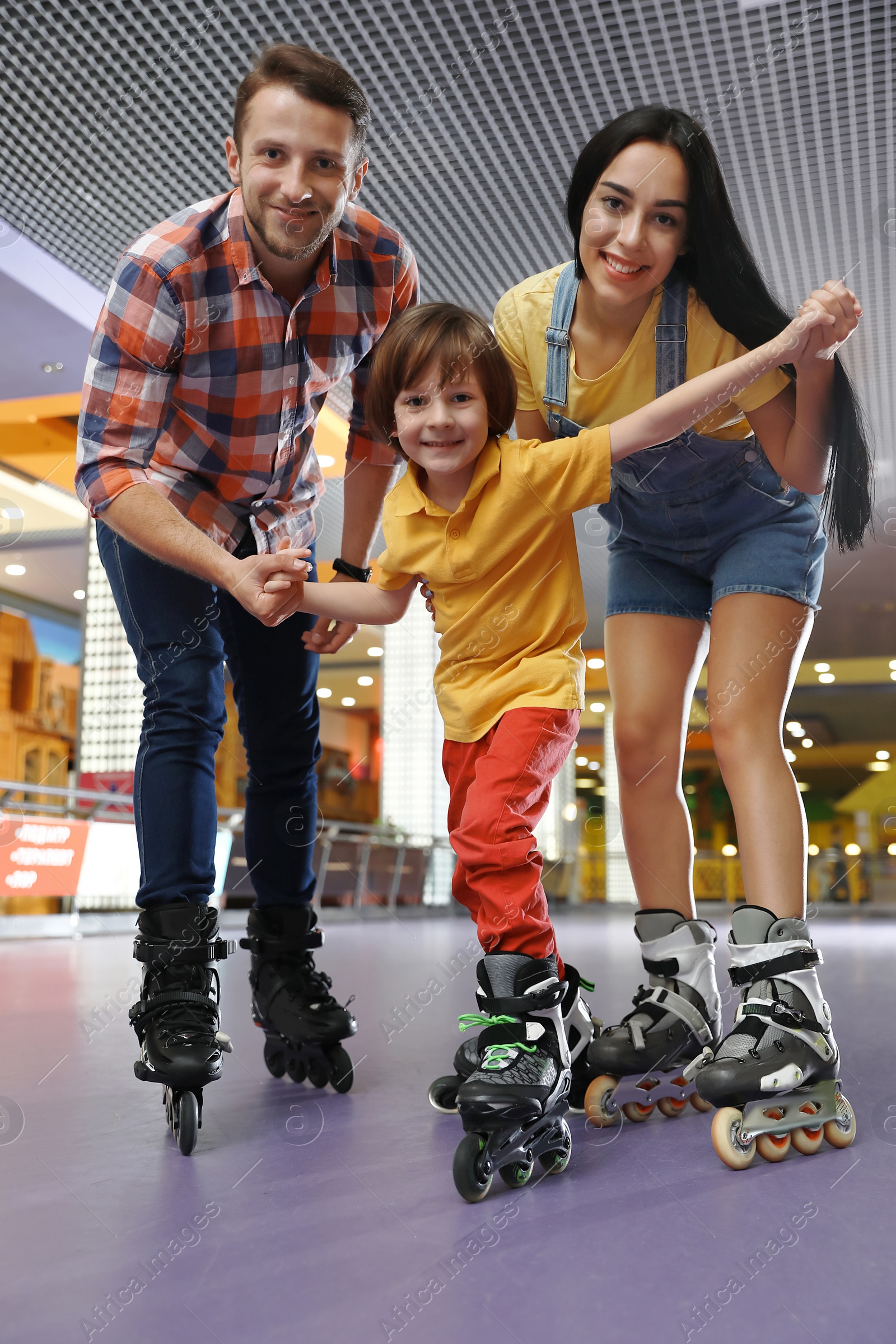 Photo of Happy family spending time at roller skating rink