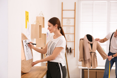 Fashion designer with colleague creating new clothes in studio