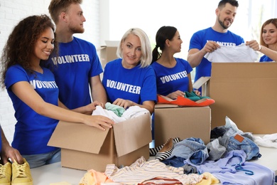 Team of volunteers collecting donations in boxes indoors