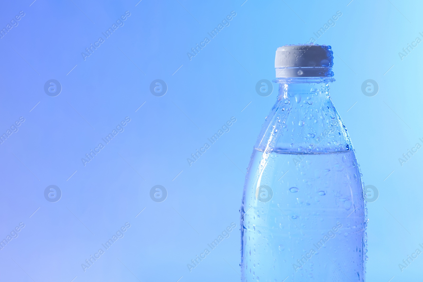 Photo of Plastic bottle of pure water on color background, closeup. Space for text