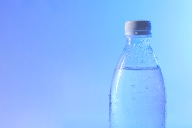 Photo of Plastic bottle of pure water on color background, closeup. Space for text