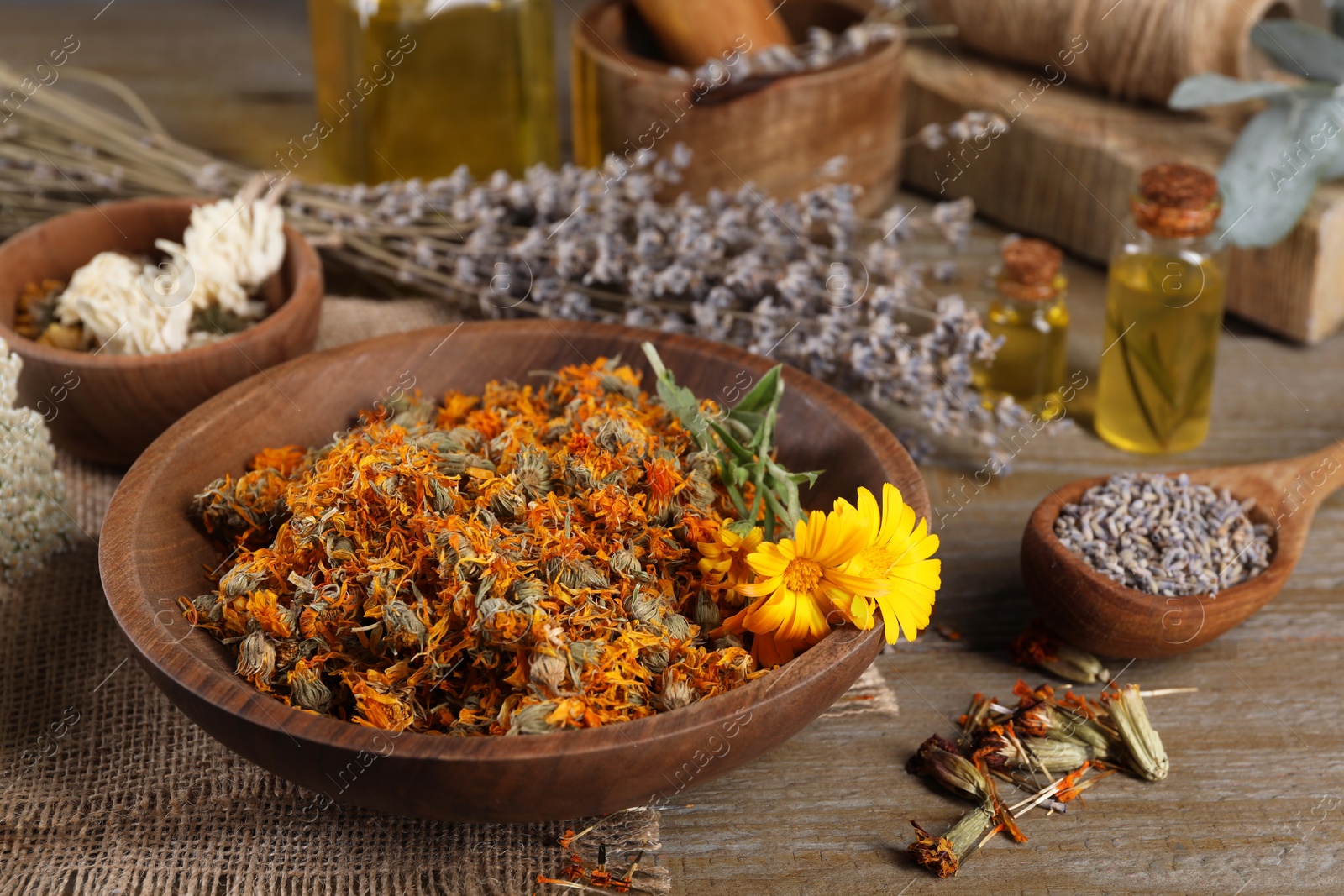 Photo of Bowl and many different herbs on wooden table