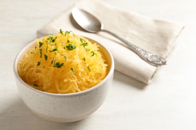 Bowl with cooked spaghetti squash on white table