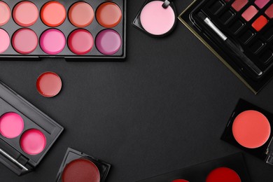 Photo of Flat lay composition with cream lipstick palettes on black background, space for text. Professional cosmetic product