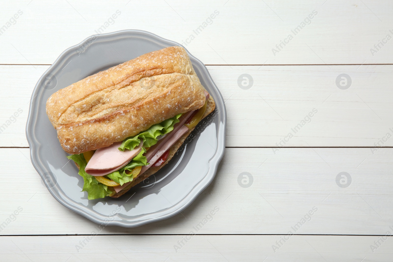 Photo of Tasty sandwich with boiled sausage, cheese and vegetables on white wooden table, top view. Space for text