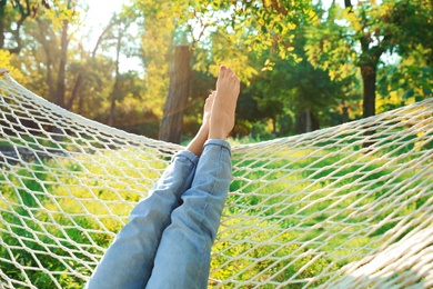 Young woman resting in comfortable hammock at green garden, closeup