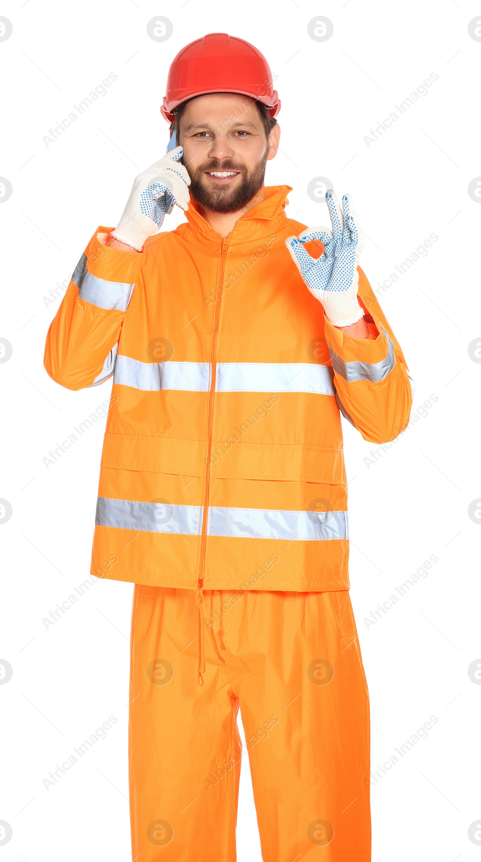 Photo of Man in reflective uniform talking on smartphone against white background