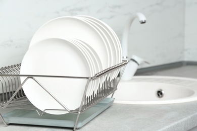 Different clean plates in dish drying rack on kitchen counter