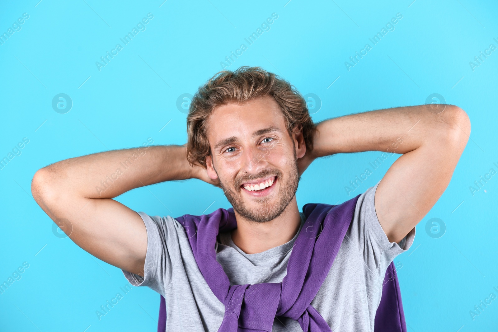 Photo of Handsome young man laughing on color background