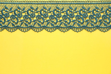 Green lace on yellow background, top view. Space for text