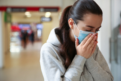 Woman wearing disposable mask indoors. Dangerous virus