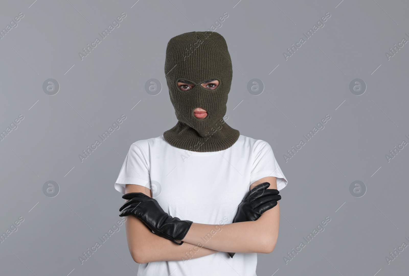 Photo of Woman wearing knitted balaclava on grey background