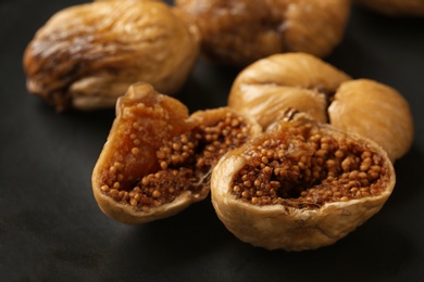 Photo of Delicious dried figs on black background, closeup. Organic snack