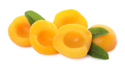 Photo of Sweet canned peach halves with mint isolated on white