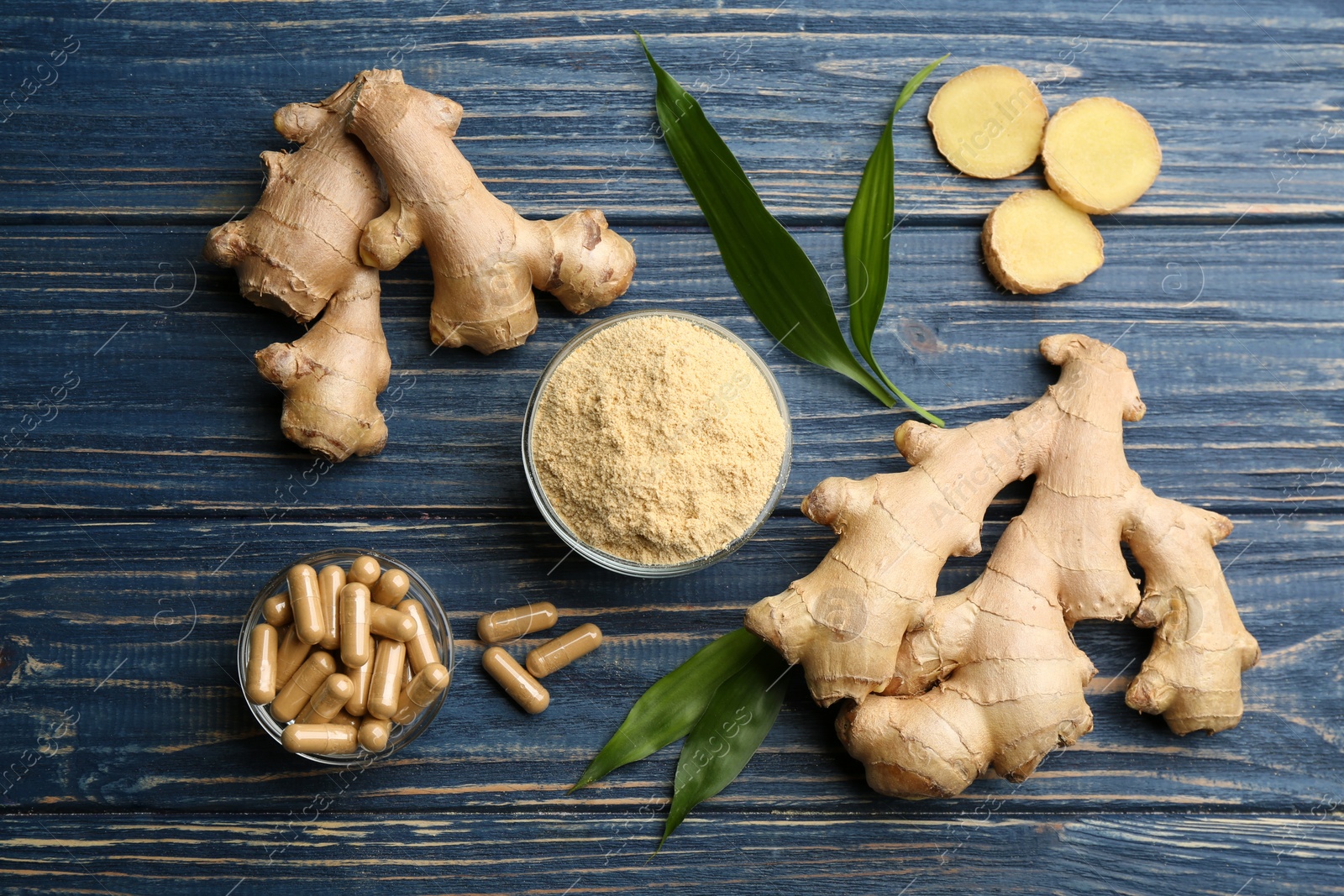 Photo of Flat lay composition with dry, fresh and capsuled ginger on blue wooden table