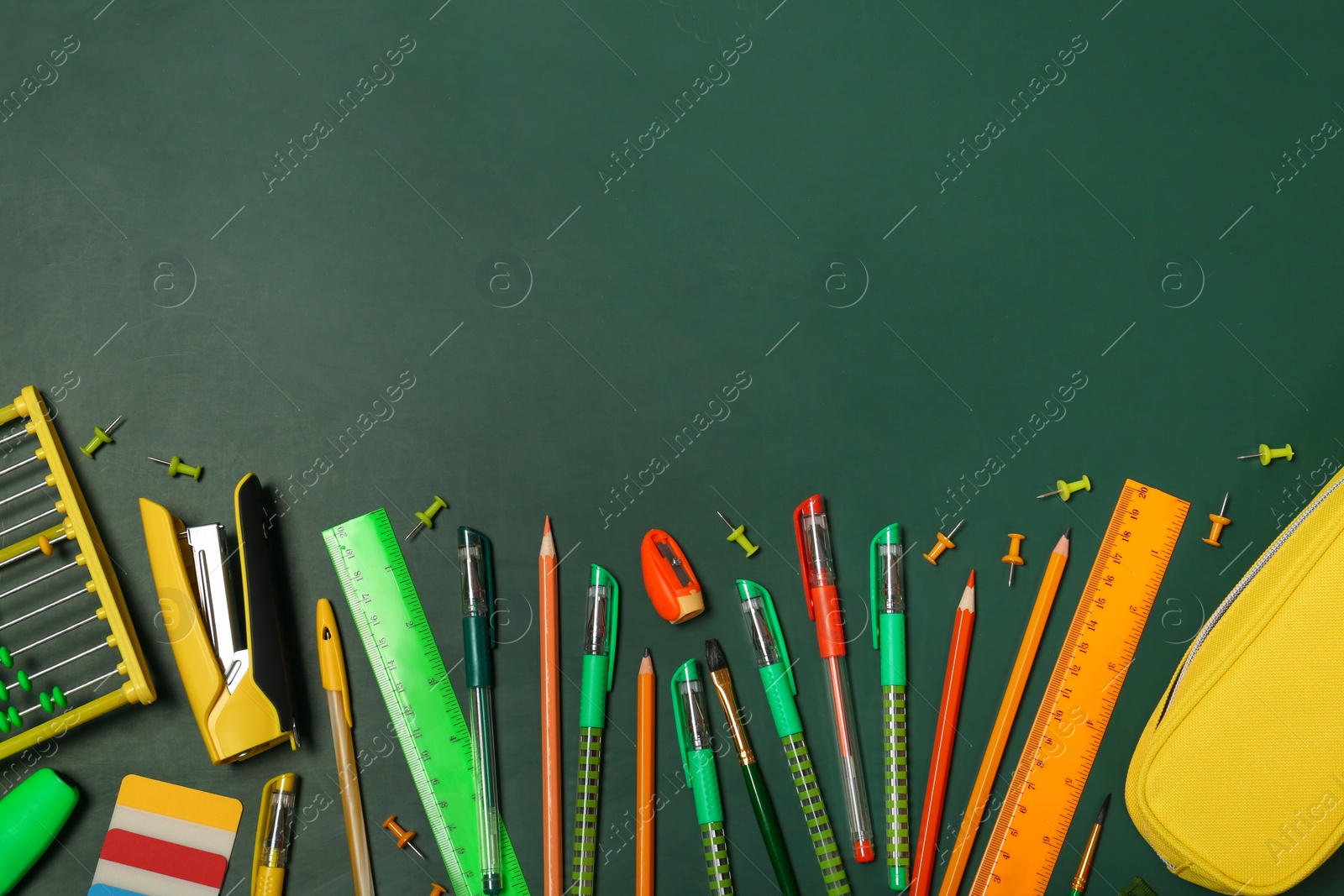 Photo of Flat lay composition with different school stationery on chalkboard surface